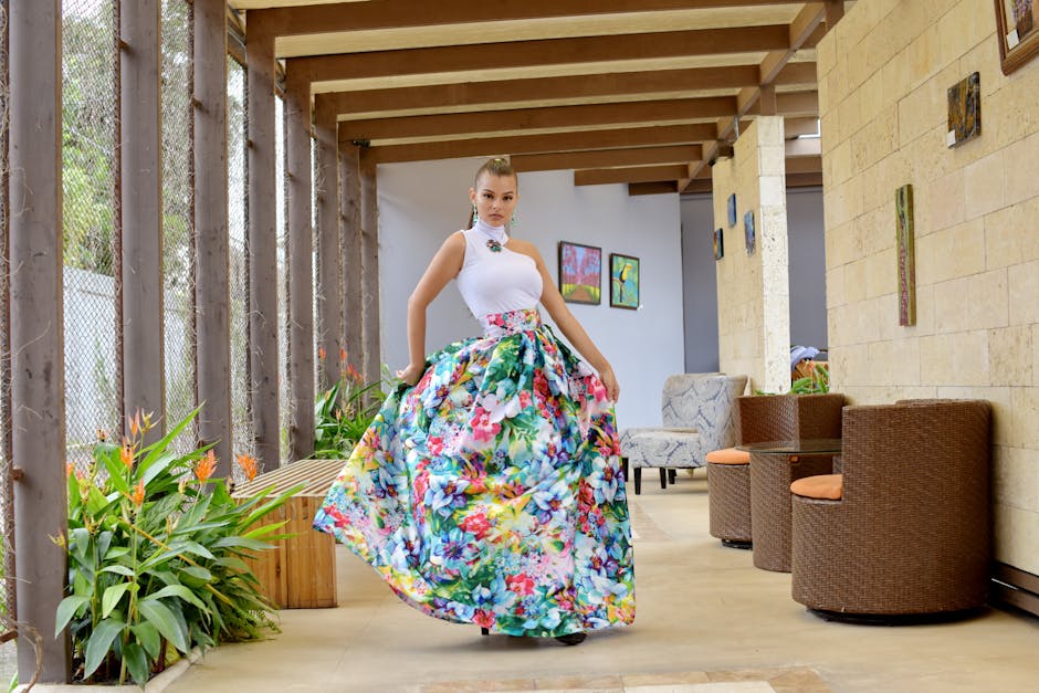 Stylish woman in a floral skirt poses confidently indoors with elegant decor.