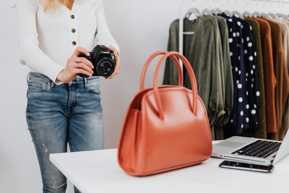 Stylish fashion photo shoot setup with handbag, clothes, and camera.